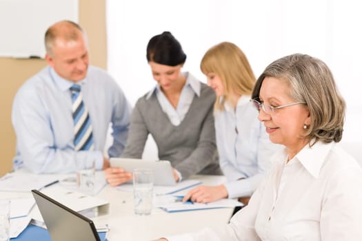 Business team meeting executive senior businesswoman with colleagues looking tablet