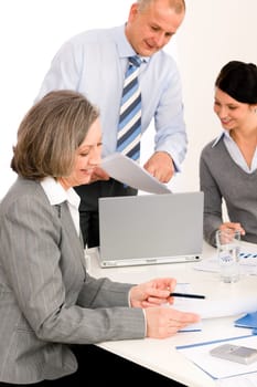 Business team meeting executive senior businesswoman with colleagues pointing report