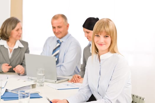 Businesswoman smiling at team meeting with colleagues