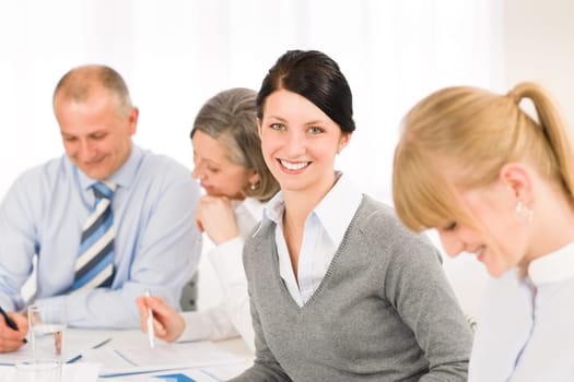 Businesswoman smiling at team meeting with colleagues