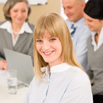 Businesswoman smiling at team meeting with colleagues