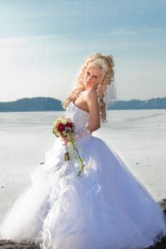 Beautiful bride in the winter forest. Beautiful blonde.