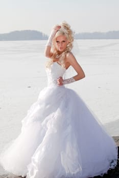 Beautiful bride in the winter forest. Beautiful blonde.