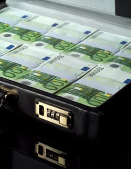 Briefcase with money isolated on black background