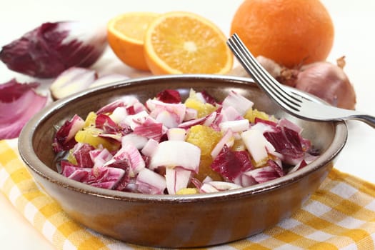 a bowl of chicory salad with shallots and orange