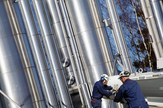 two engineers working with large gas and oil pipelines