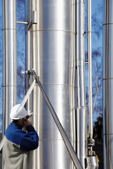 engineer, worker, pointing at large pipelines, oil, gas and fuel