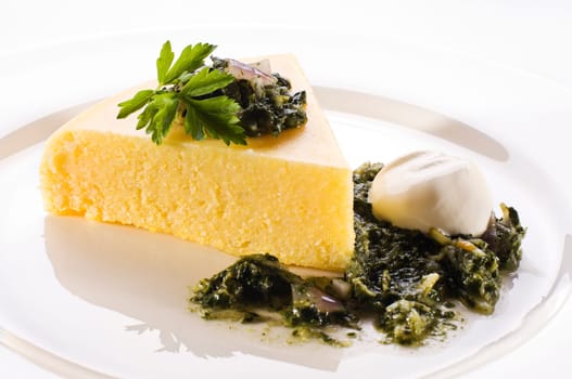 Fresh polenta with spinach and cream close up