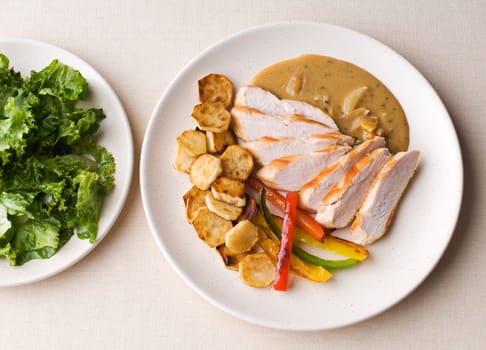 Fresh sliced chicken with roasted potato and pepper close up