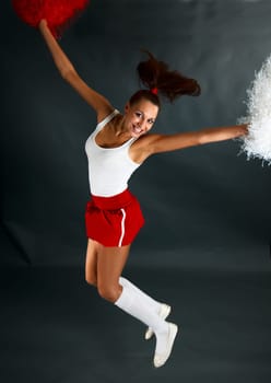 Young lady cheerleader posing in the studio.