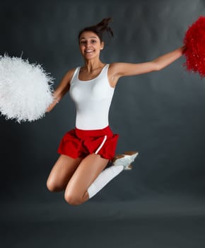 Young lady cheerleader posing in the studio.
