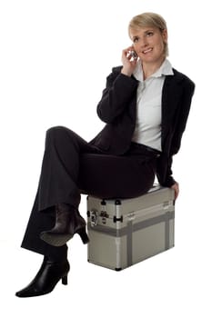 young business women sitting on case and talking on mobile