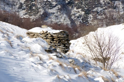 stone building in the mountains in winter