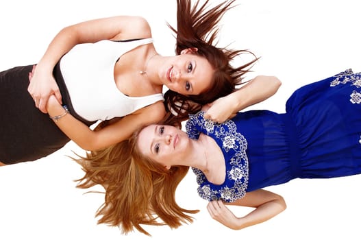 Two bretty woman with long hair lying head on head on the floor, one blond, one brunette and there hair spreat out, over white.
