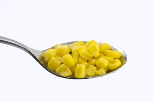 steamed corn seeds in a spoon on isolated background