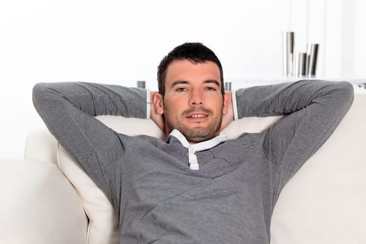 relaxed man sitting on sofa at home