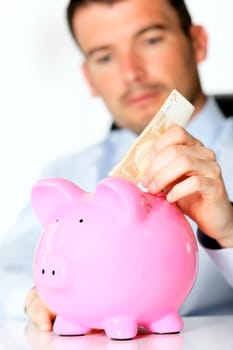 hand of man with bill and pink piggy bank