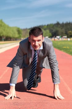 handsome businessman on a running track in summer