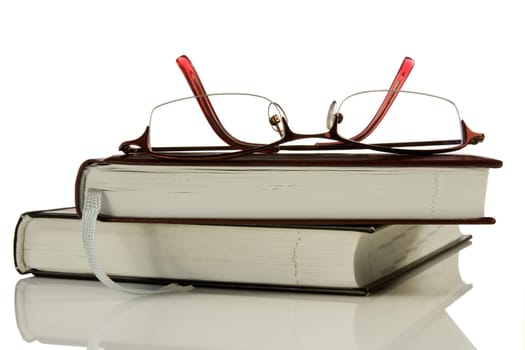 books and glasses isolated over a white background.