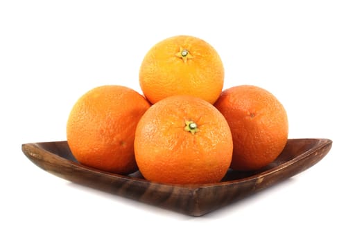 Oranges on a wooden plate against a white background