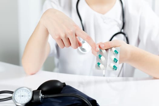 woman doctor showing pills to the patient