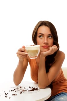 Dreaming young woman with a cup of cappuccino coffee against white background