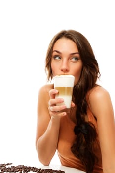 Beautiful woman drinking latte macchiato coffee and looking to the side against white background