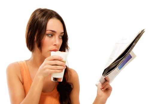 Beautiful woman reading newspaper and drinking latte macchiato coffee against white background