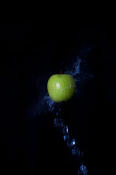 Shot of apple and splash on black background