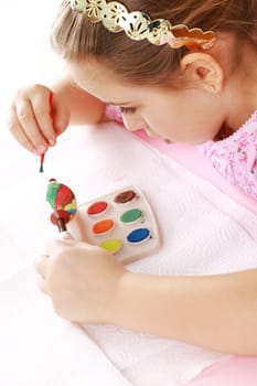 Cute little girl painting Easter eggs