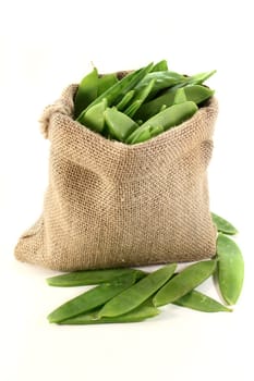 green sugar snap peas in a jute bag