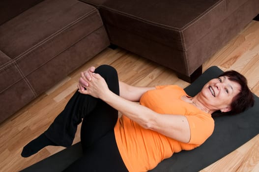 Mature fitness woman exercising at home