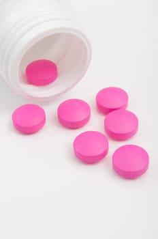 Pink Pills in White Bottle On White Background