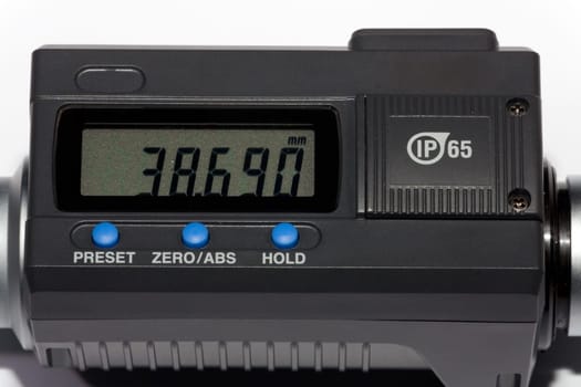 Detail view of digital display of micrometer screw against white background