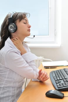 Young business person wearing headset suffering neck pain. Profile view.