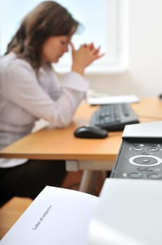 Detail of business woman in depression on workplace. Letter of resignation went from printer (shallow deptht of field).