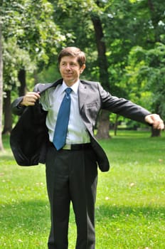 Returtn to civilization - senior business man putting on jacket park after break