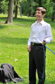 Escape from civilization - smiling senior business man putting off tie and relaxing in fresh green park