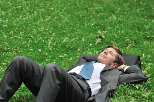 Senior people series - mature business man lying in grass and relaxing with copy space