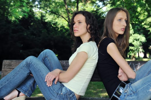 Friends outdoors series - two teenage girls are in conflick and do not speak with each another