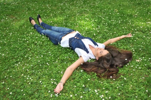 Young woman lying in grass with flowers