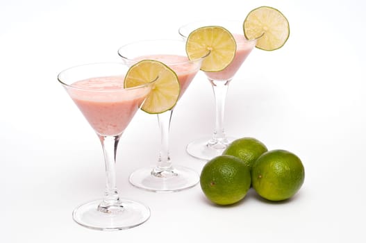 Three cocktail glasses with buttermilk,papaya and limes