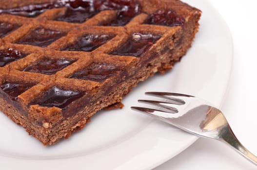 A Linz cake with a cake fork on a white plate
