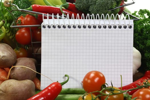 a checkered notepad and various vegetables