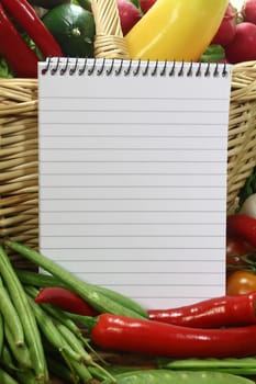 a lined notepad and various vegetables