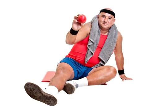 Large fitness man with an apple isolated in white