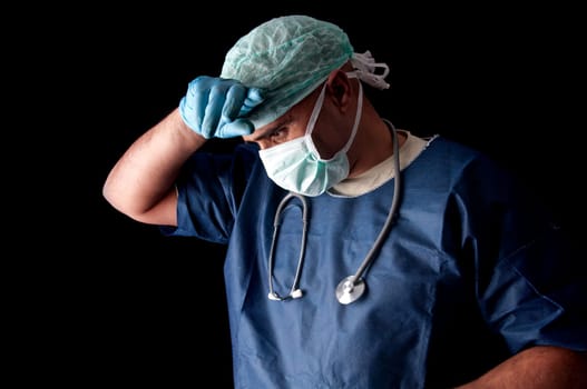 Tired doctor with mask in a dark background