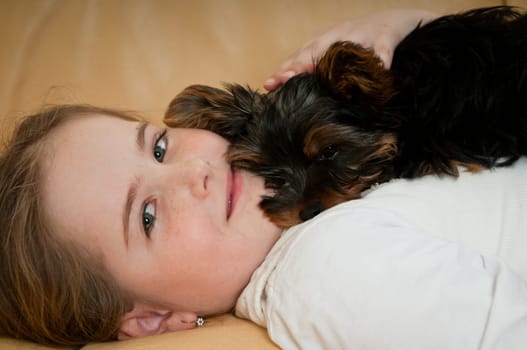 Portrait of cute child (girl) relaxing with little dog