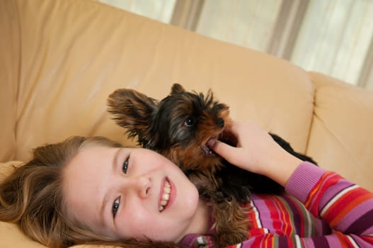 Portrait of cute child (girl) relaxing with little dog