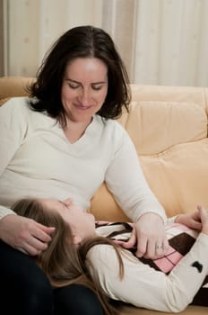 Child (cute ligirl) kissing her mother - indoors at home